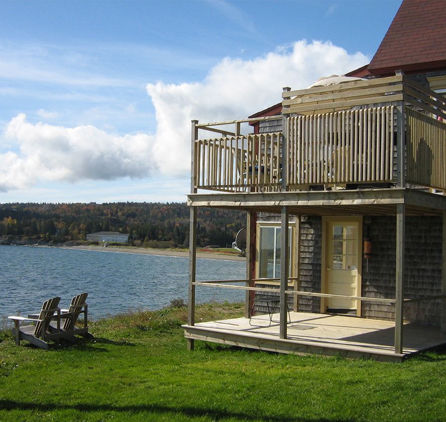 Lakeside cabin with wooden deck and balcony in rural Canada